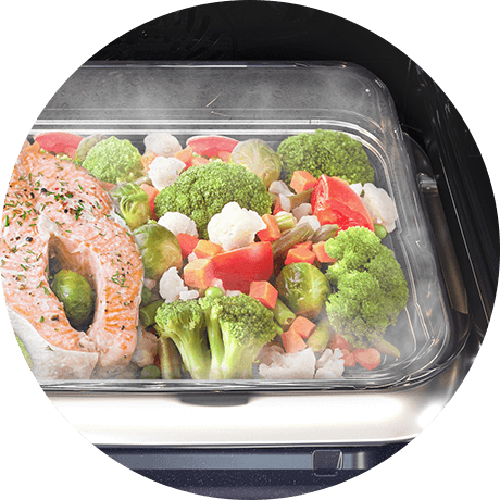 Naczynie Steam Cook wypełnione gotowanymi na parze warzywami z łososiem pokazuje możliwości piekarnika Samsung NV7B6685AAN