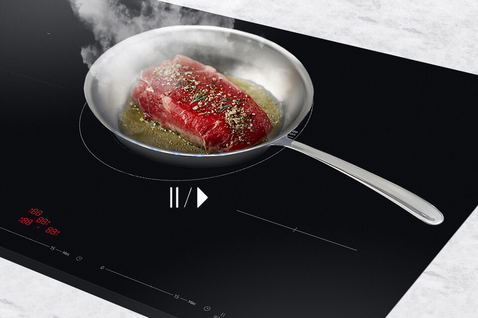 Widok na smażące się mięso na patelni, umieszczonej na płycie grzewczej Samsung 